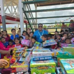 Minister Mustapha distributing toys to children from Annai