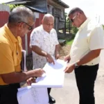 Minister Croal and the Director of the Community Development Department at the Central Housing and Planning Authority, Gladwin Charles examining a plan for a squatting area in Region Three