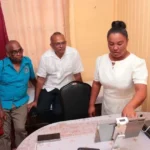 One of the community health workers at Imbotero health post shows Minister Anthony the procedure of telemedicine