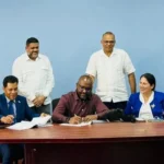 MOU being signed by the Managing Director of RioMed Limited Mario Mohamed (Sitting L) and Permanent Secretary of the Ministry of Health, Malcolm Watkins