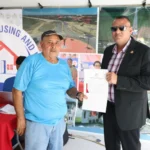 Minister of Housing and Water Collin Croal presents Vincent Mittelholzer with his land title