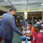 President, Dr Mohamed Irfaan Ali, with family members of two shooting victims in Linden, Region Ten, on Tuesday night